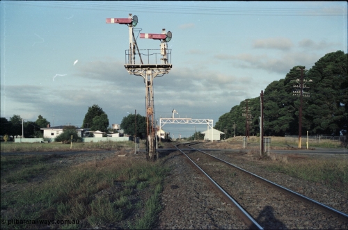125-01
Ballan station overview, looking toward Melbourne from up home signal post 7B, signal posts, water tank between trees on LHS.
