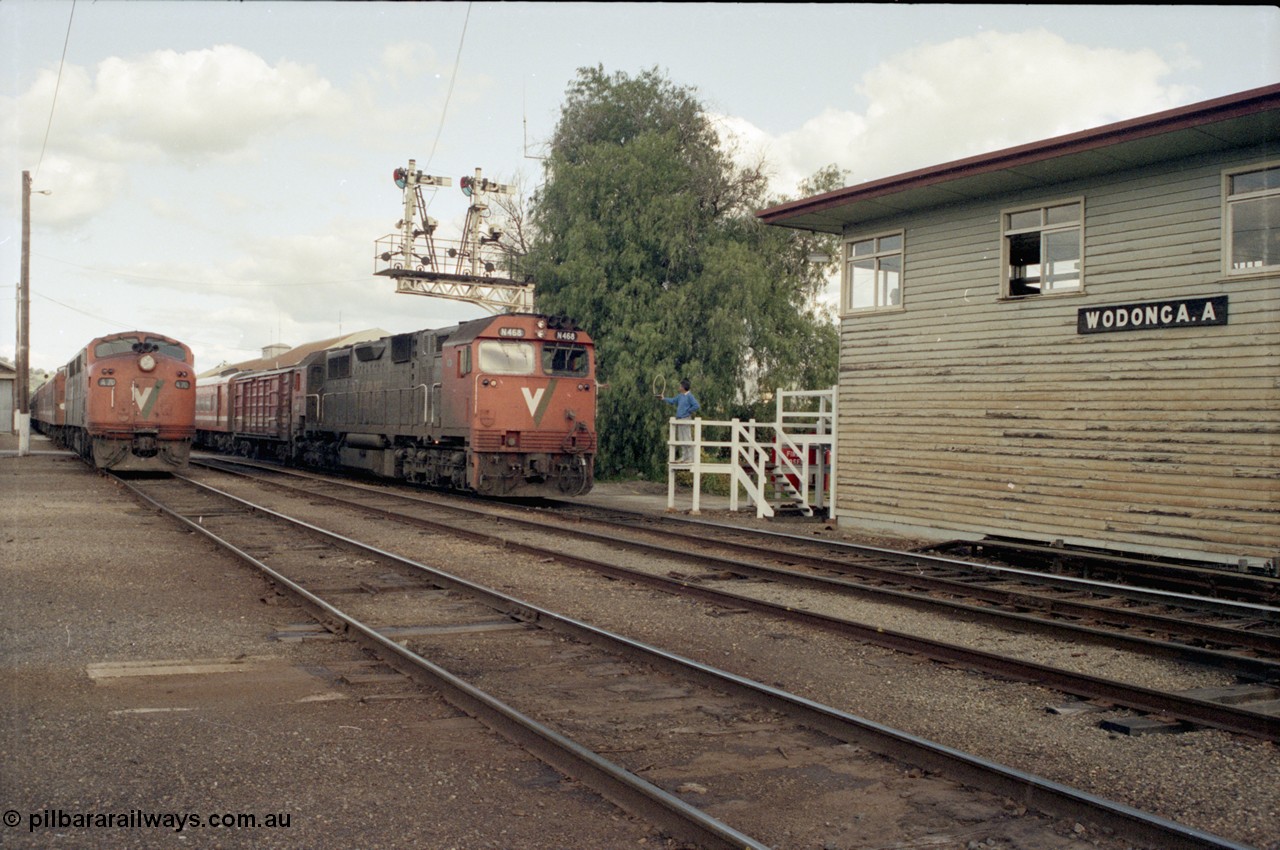 127-09
Wodonga broad gauge V/Line N class N 468 'City of Bairnsdale' Clyde Engineering EMD model JT22HC-2 serial 86-1197 leads the afternoon up Albury passenger train past stabled A 70 Clyde Engineering EMD model AAT22C-2R serial 84-1187 rebuilt from B 70 Clyde Engineering EMD model ML2 serial ML2-11, as the Wodonga signaller offers up the electric staff for the section to Springhurst to the driver.
Keywords: N-class;N468;Clyde-Engineering-Somerton-Victoria;EMD;JT22HC-2;86-1197;