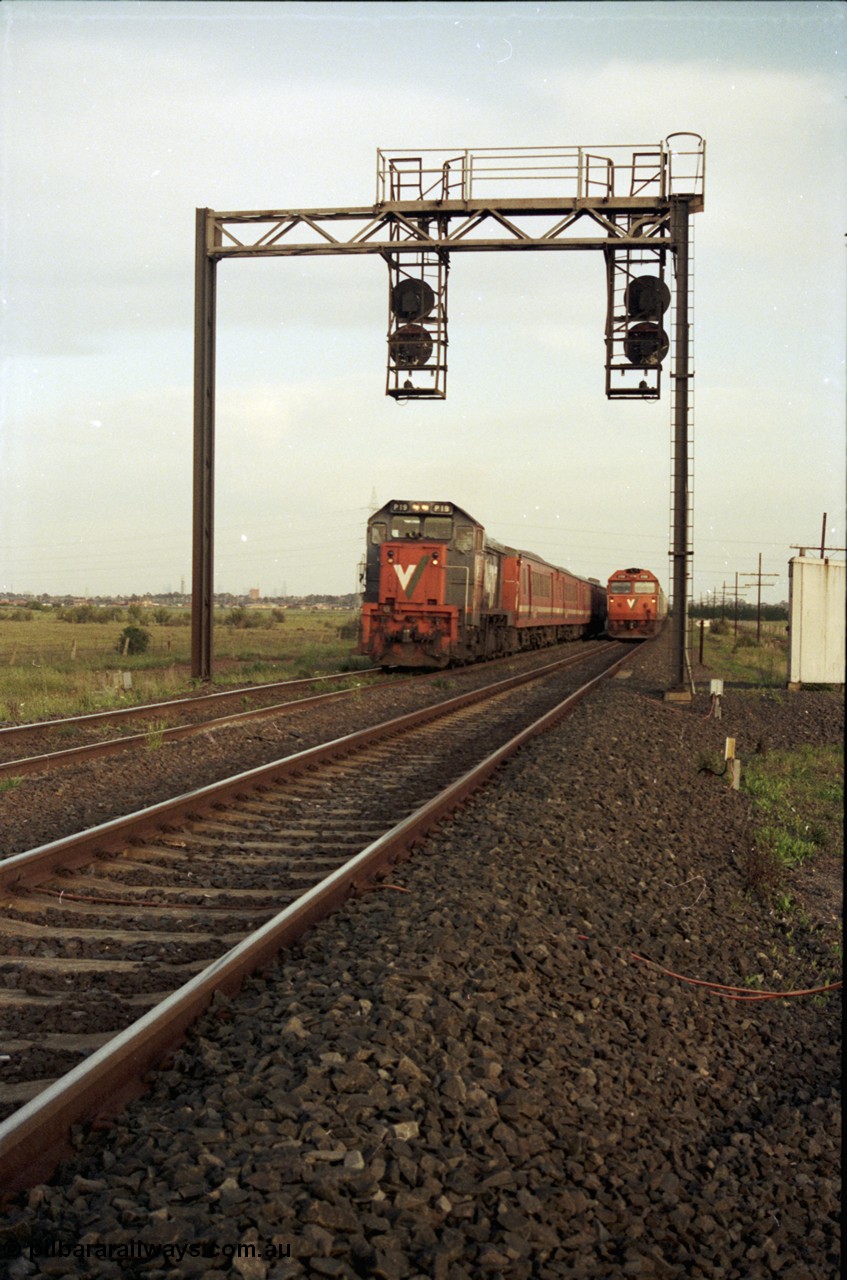 127-22
Deer Park West, broad gauge V/Line P class P 19 Clyde Engineering EMD model G18HBR serial 84-1212 rebuilt from T 331 Clyde Engineering EMD model G8B serial 56-98 with H set overtakes a V/Line G class on a down goods at the end of the double track, searchlight signal gantry.
Keywords: P-class;P19;Clyde-Engineering-Somerton-Victoria;EMD;G18HBR;84-1212;rebuild;