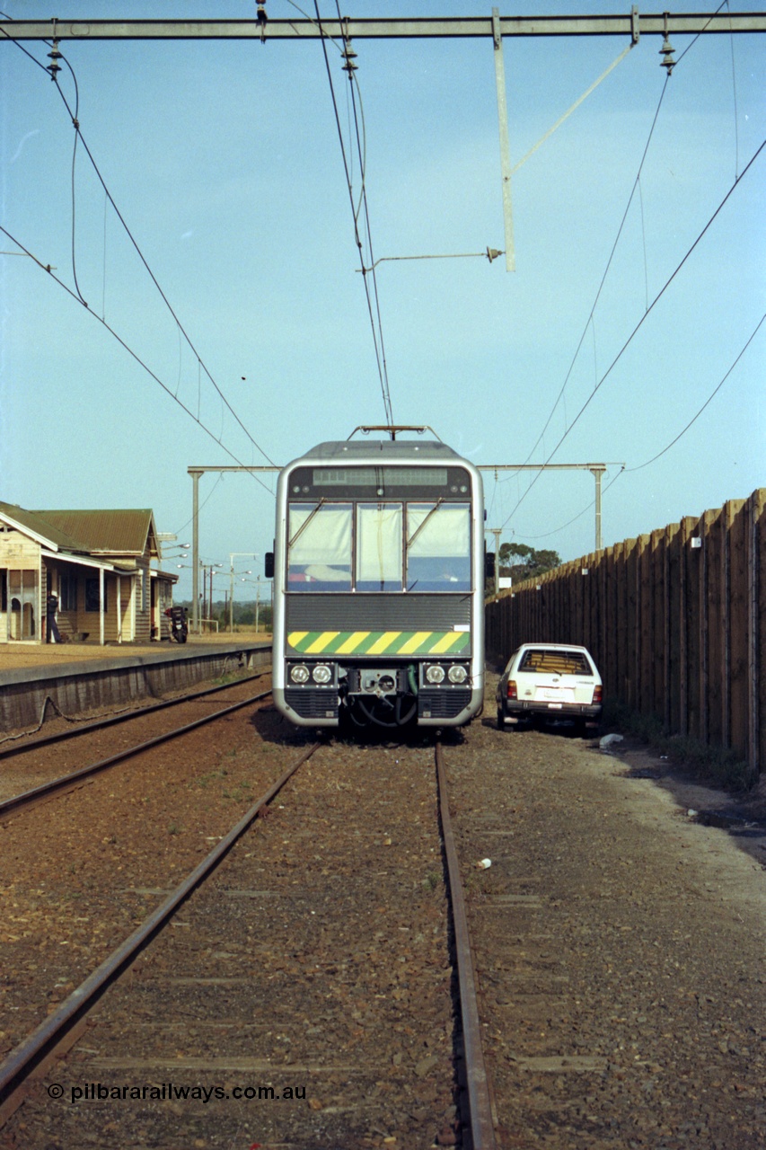 128-26
Nar Nar Goon, 4D (Double Deck Development and Demonstration), double deck suburban electric set, stabled during testing phase, cab front, station building and platform, car next to train is for security guard.
