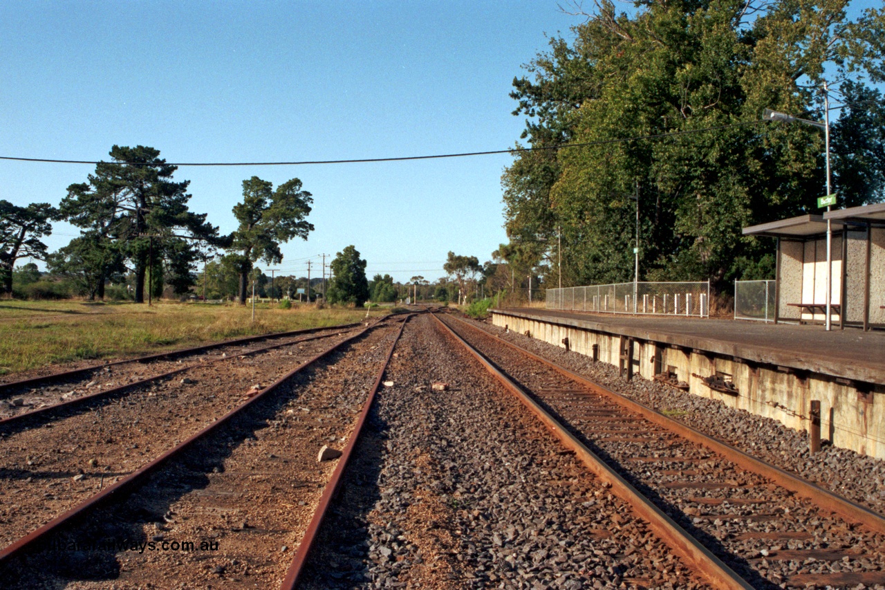 129-1-17
Baxter, station yard overview, looking towards Somerville, station platform and bus type concrete shelter, signal wires visible exiting platform coping, off focus.
