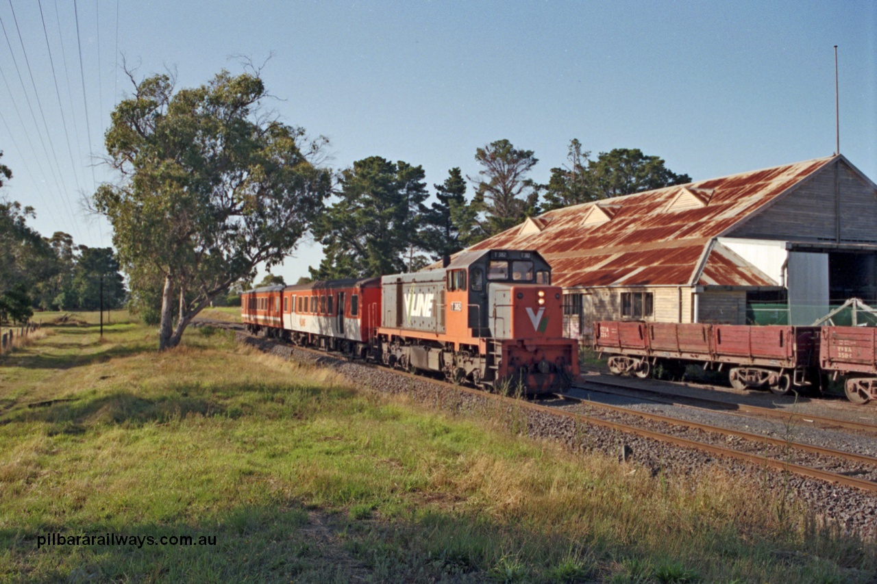 129-1-23
Somerville, broad gauge V/Line T class T 382 Clyde Engineering EMD model G8B serial 64-337 arriving with up Stony Point passenger service consisting of two MTH class trailers, VZOA type bogie dirty ballast waggon VZOA 231, old cool stores in background.
Keywords: T-class;T382;Clyde-Engineering-Granville-NSW;EMD;G8B;64-337;MTH-class;VZOA-type;