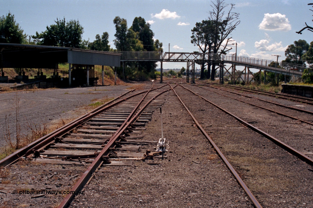 129-2-29
Leongatha yard overview, looking towards Melbourne, footbridge, Victorian Railways liveried RT class rail tractor RT 39 under cover, points and point lever.
