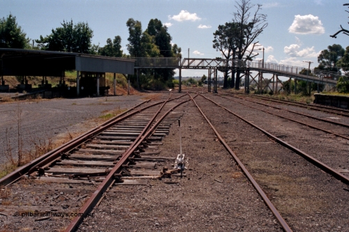 129-2-29
Leongatha yard overview, looking towards Melbourne, footbridge, Victorian Railways liveried RT class rail tractor RT 39 under cover, points and point lever.
