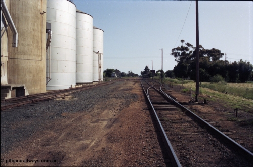 130-07
Elmore yard overview, looking north, silo complex at left, Williamstown concrete and Ascom steel silos, points set for platform road.
