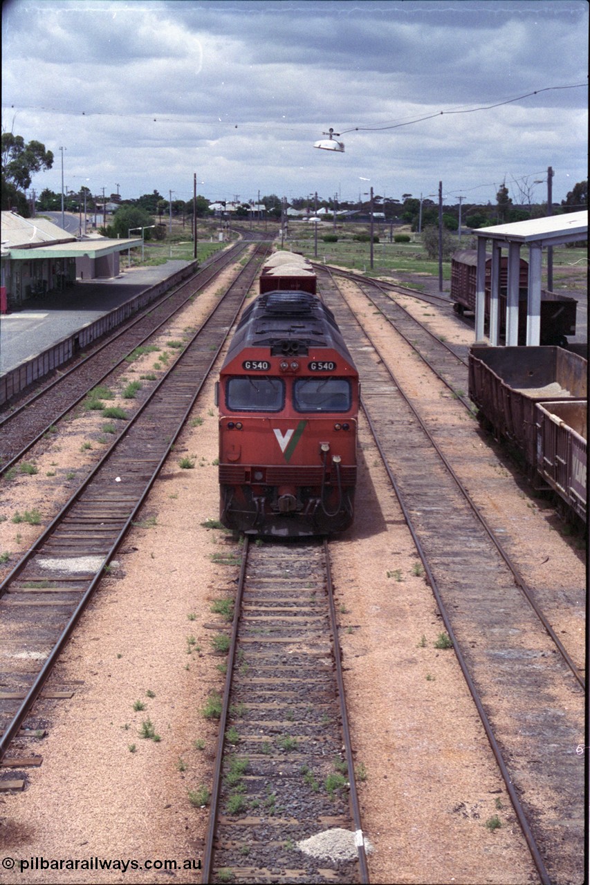 132-05
Ouyen station overview, broad gauge V/Line G class G 540 Clyde Engineering EMD model JT26C-2SS serial 89-1273 with stabled up gypsum train 9138, looking south from footbridge, station building and platform, Freightgate canopy.
Keywords: G-class;G540;Clyde-Engineering-Somerton-Victoria;EMD;JT26C-2SS;89-1273;