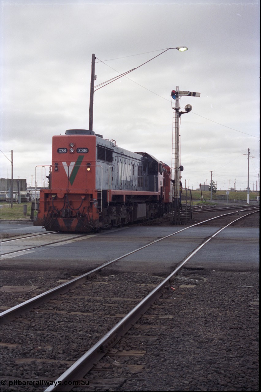 133-07
North Geelong C Box, Separation Street grade crossing, V/Line broad gauge down Ararat passenger train 8105 powered by long end leading X class X 38 Clyde Engineering EMD model G26C serial 70-701 obtains the electric staff for the section to Gheringhap, semaphore signal post 16, signaller, staff exchange, safeworking.
Keywords: X-class;X38;Clyde-Engineering-Granville-NSW;EMD;G26C;70-701;