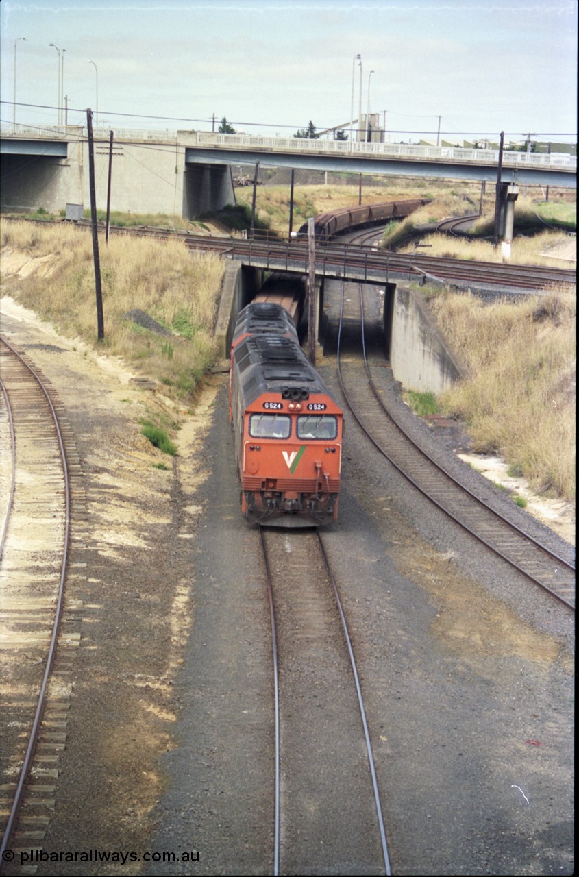 133-14
North Geelong, V/Line broad gauge G class locos G 524 Clyde Engineering EMD model JT26C-2SS serial 86-1237 and G 528 serial 88-1258 work a loaded grain train under the Geelong running lines bound for the grain loop, the track at left is the derelict connection to Geelong Yard, and the track at right is the grain loop departure road.
Keywords: G-class;G524;Clyde-Engineering-Rosewater-SA;EMD;JT26C-2SS;86-1237;