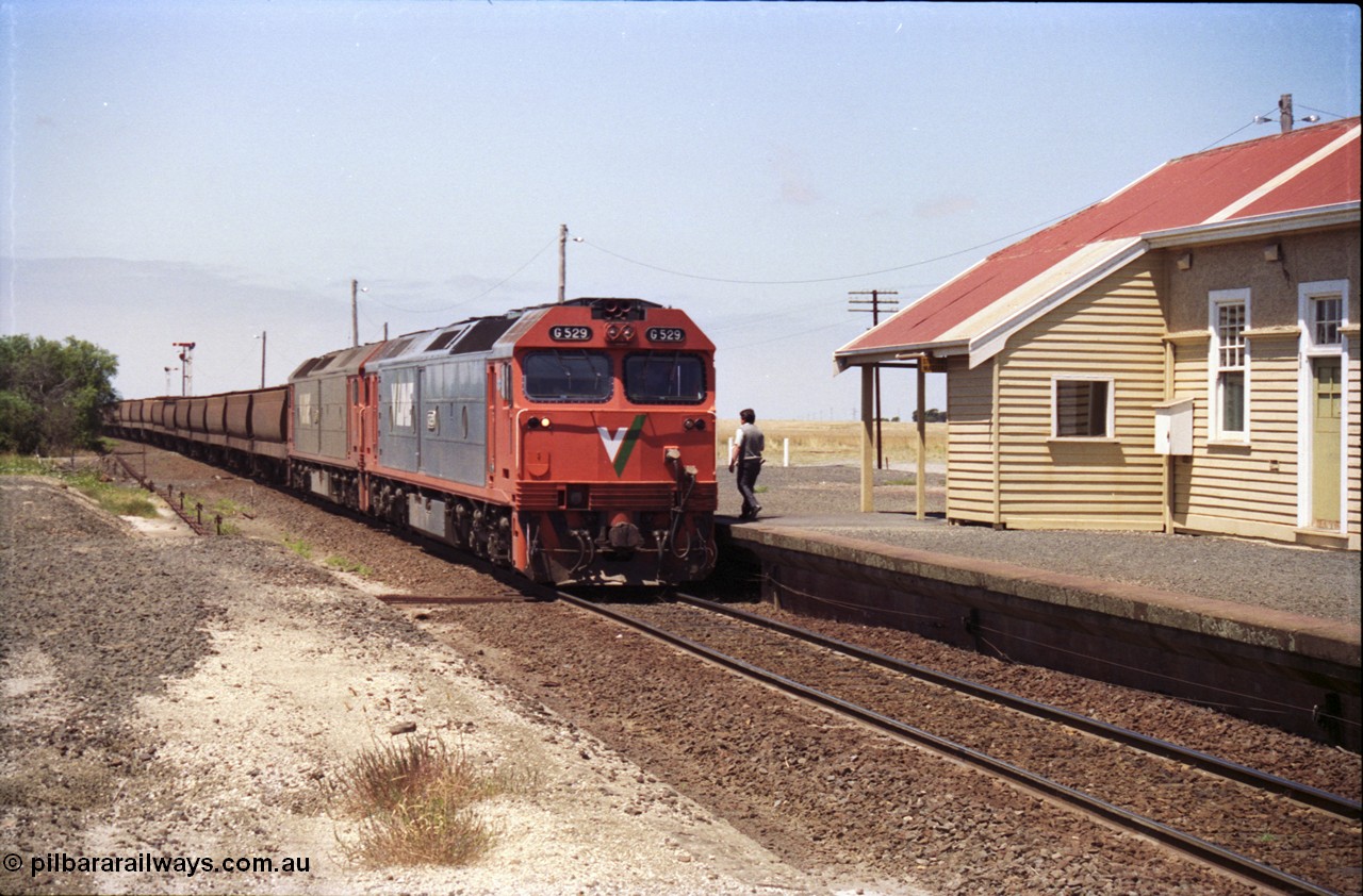 133-16
Gheringhap station building, V/Line broad gauge grain train 9121 heading to Ballarat and beyond, G classes G 529 Clyde Engineering EMD model JT26C-2SS serial 88-1259 and G 511 serial 84-1239 pause to exchange electric staves, safeworking.
Keywords: G-class;G529;Clyde-Engineering-Somerton-Victoria;EMD;JT26C-2SS;88-1259;