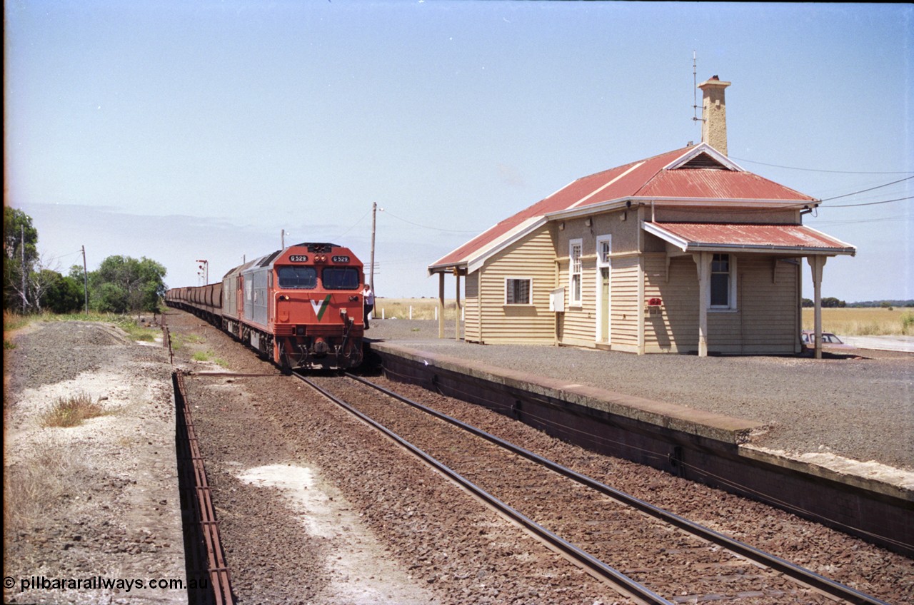 133-17
Gheringhap station building, V/Line broad gauge grain train 9121 heading to Ballarat and beyond, G class G 529 Clyde Engineering EMD model JT26C-2SS serial 88-1259 and G 511 serial 84-1239 pause to exchange electric staves, driver boarding loco, point rodding, safeworking, from former No.2 platform.
Keywords: G-class;G529;Clyde-Engineering-Somerton-Victoria;EMD;JT26C-2SS;88-1259;