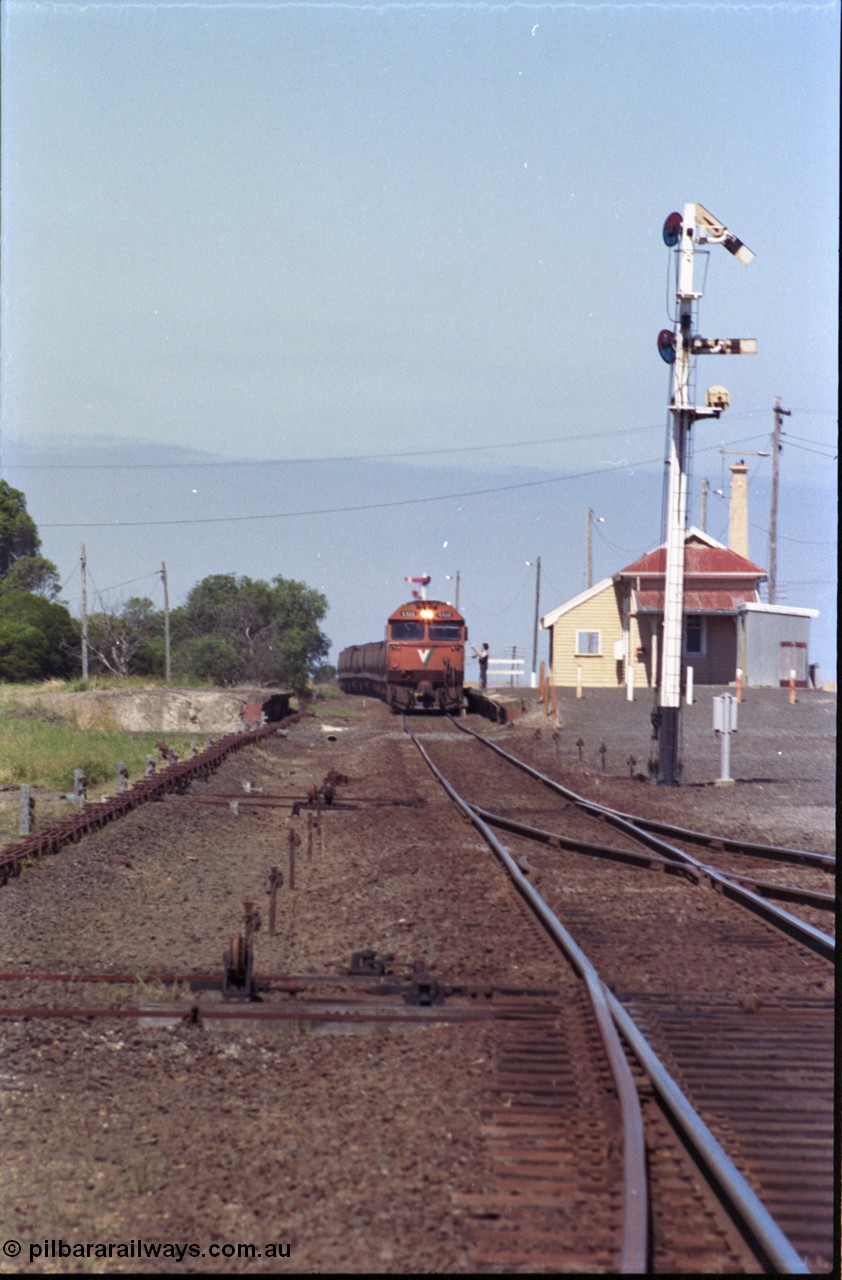 133-30
Gheringhap station yard overview, looking from Ballarat line points towards Geelong, semaphore signal post 4 pulled off for Cressy line, points, point rodding, signal wires and interlocking, V/Line broad gauge grain train 9123 swapping electric staff for train order for Maroona, safeworking.
Keywords: G-class;G533;Clyde-Engineering-Somerton-Victoria;EMD;JT26C-2SS;88-1263;