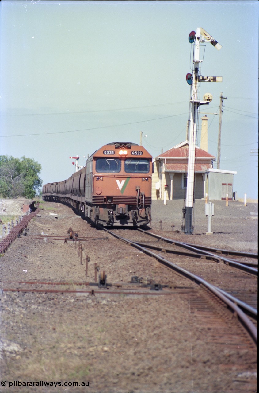 133-33
Gheringhap station yard overview, looking from Ballarat line points, semaphore signal post 4 pulled off for Cressy line, points, point rodding, signal wires and interlocking, V/Line broad gauge down empty grain train 9123 behind G class loco G 533 Clyde Engineering EMD model JT26C-2SS serial 88-1263.
Keywords: G-class;G533;Clyde-Engineering-Somerton-Victoria;EMD;JT26C-2SS;88-1263;