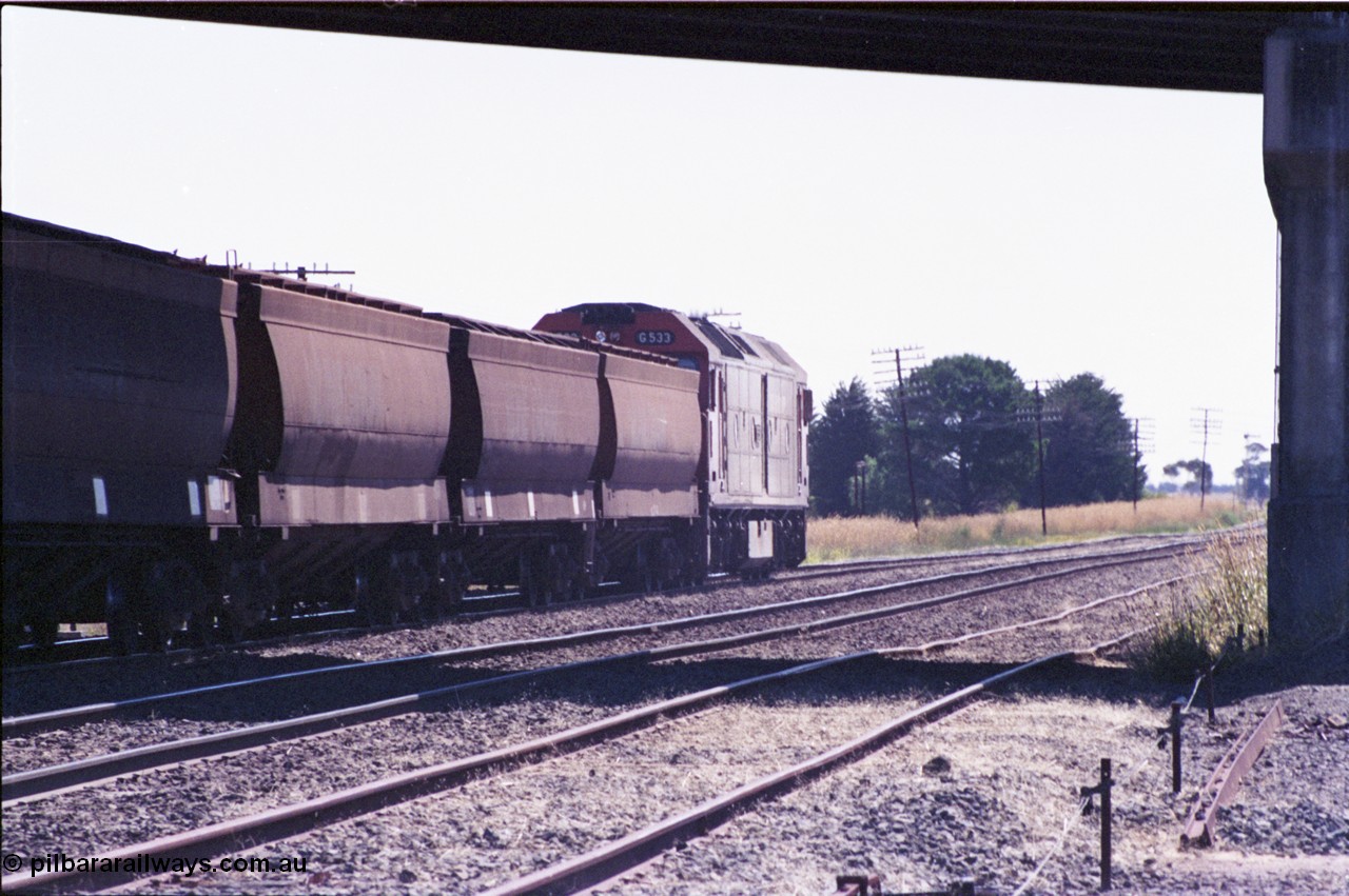 133-35
Gheringhap, trailing shot of V/Line broad gauge down empty grain train 9123, under the road bridge, G class G 533 Clyde Engineering EMD model JT26C-2SS serial 88-1263, poor quality image.
Keywords: G-class;G533;Clyde-Engineering-Somerton-Victoria;EMD;JT26C-2SS;88-1263;