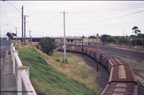 133-10
North Geelong grain loop, empty train being worked back to North Geelong C by V/Line broad gauge G class locos G 528 Clyde Engineering EMD model JT26C-2SS serial 88-1258 and G 524 serial 86-1237, grain train, taken from Corio Quay Rd, trailing shot.
