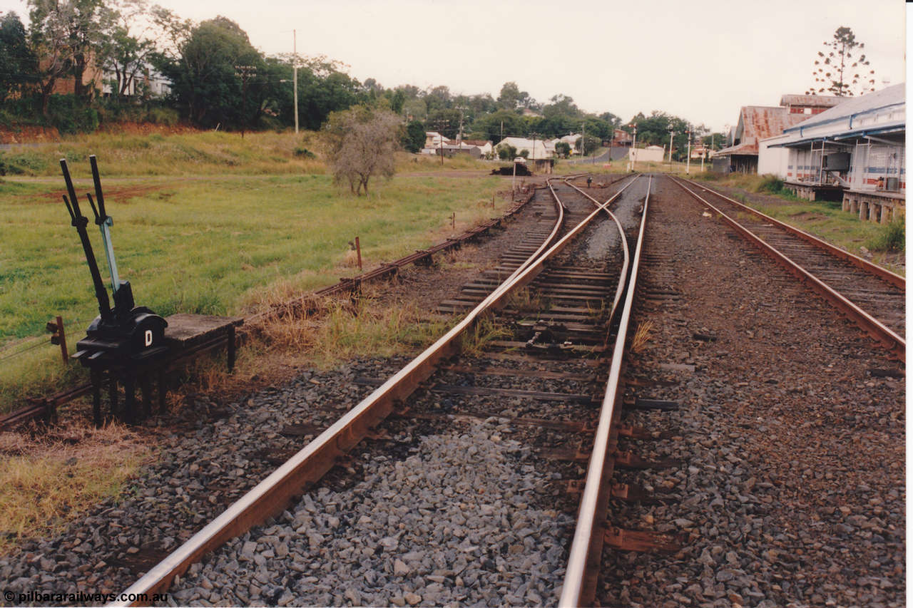134-21
Kyogle, yard overview, looking south from middle of loop, ground frame D for siding, point rodding and interlocking, ex rail served buildings on right.
