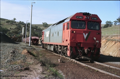 135-17
Kilmore East Apex Quarry siding overview, 2nd person riding, V/Line broad gauge G class G 540 Clyde Engineering EMD model JT26C-2SS serial 89-1273 runs around rake, loading bins in background, front end loader loading waggons.
Keywords: G-class;G540;Clyde-Engineering-Somerton-Victoria;EMD;JT26C-2SS;89-1273;
