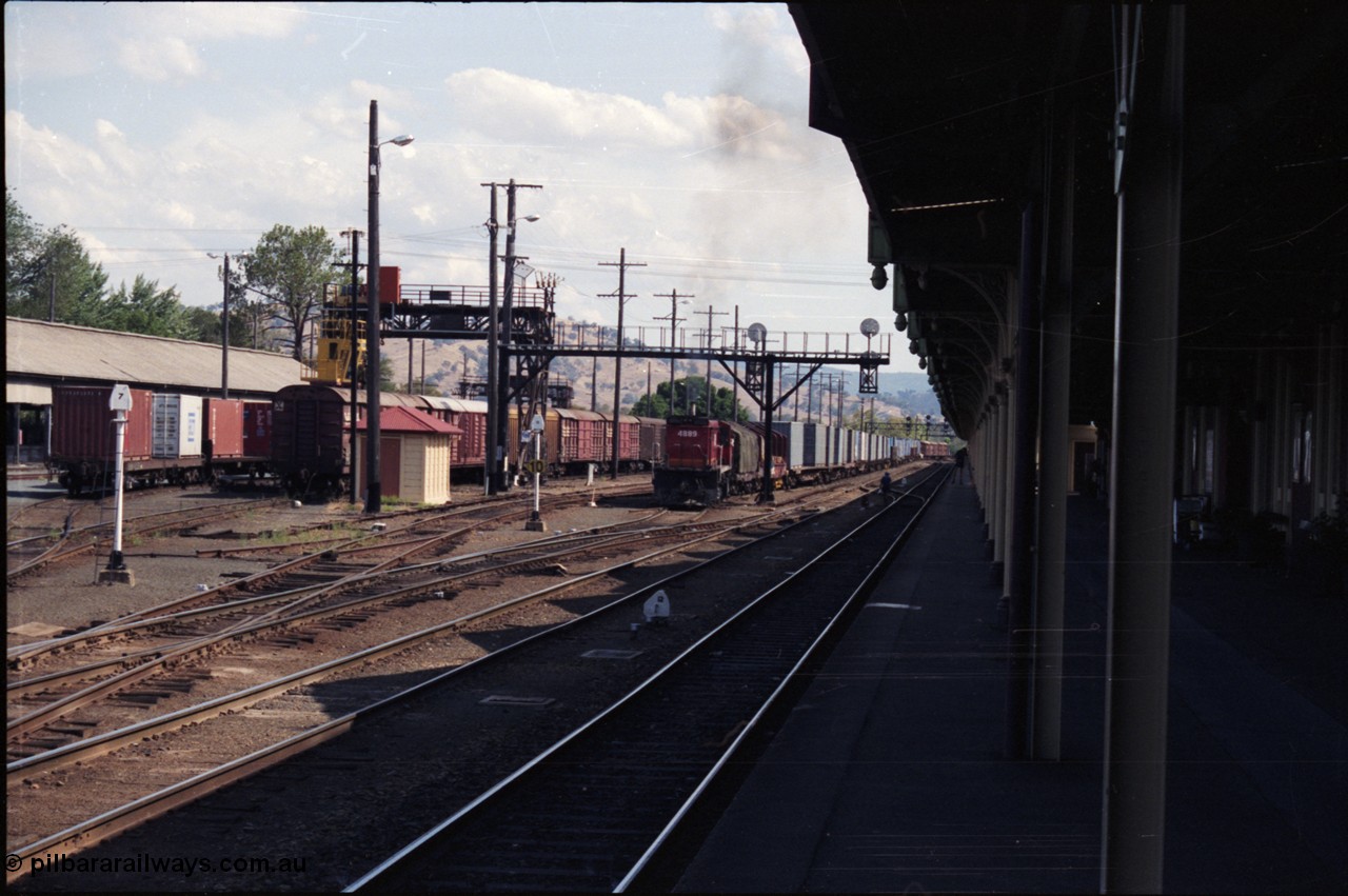 137-2-08
Albury station yard overview, standard gauge NSWSRA candy liveried 48 class 4889 AE Goodwin ALCo model DL531 serial G3420-4 shunts an arrival from Melbourne, the mixed gauge 'trans-shipping yard' is to the left of the louvre vans, and the broad gauge loop is directly to the left of the loco, the track between the two white signal posts is the broad gauge lead to the sidings on the west side of Albury yard.
Keywords: 48-class;4889;AE-Goodwin;ALCo;RSD-8;DL531;G3420-4;