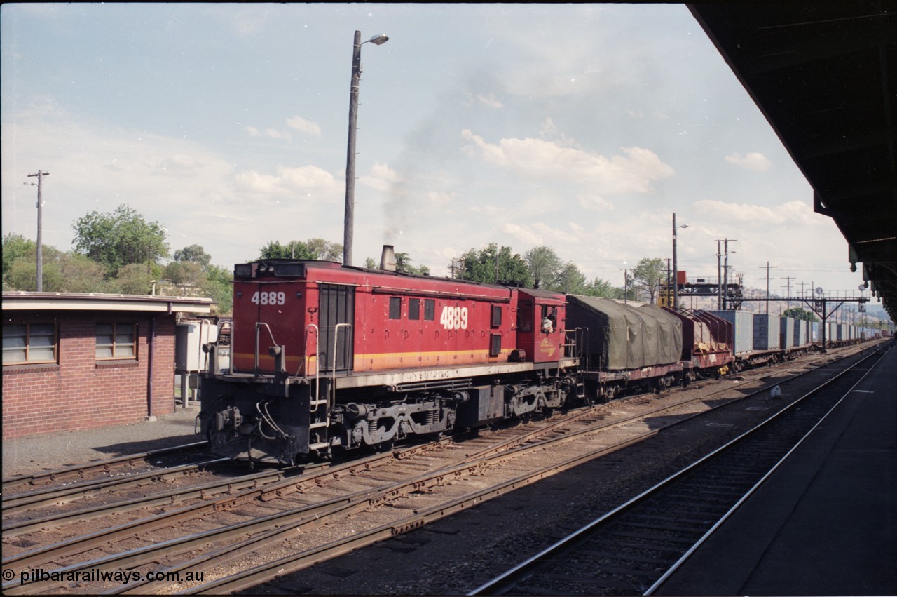 137-2-10
Albury station yard overview, standard gauge NSWSRA candy liveried 48 class 4889 AE Goodwin ALCo model DL531 serial G3420-4 shunts an arrival from Melbourne at Albury, two V/Line VCSX class bogie coil steel waggons lead the consist, the container waggons are being cut off.
Keywords: 48-class;4889;AE-Goodwin;ALCo;RSD-8;DL531;G3420-4;