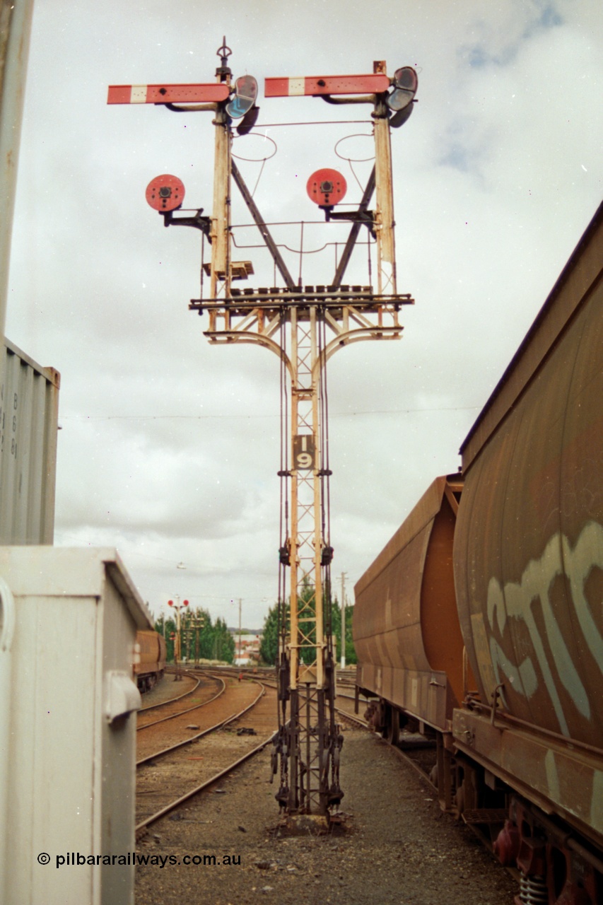 139-05
Ballarat yard, semaphore and disc signal Post 19 controlled from Ballarat Signal Box A or Ballarat Box, goods shed roads at left, goods platform roads at right, looking east. Right hand Arm Up Home No. 6 Road to the Up Passenger Line to Post 7, right hand Disc from No. 6 Road to 'D' towards Post 13, left hand Arm Up Home No. 7 Road to Up Passenger Line to Post 7 and left hand Disc from No. 7 Road to 'D' towards Post 13. The waggons at right are on No. 7 Road with the just visible grain waggons on No. 8 goods road with double disc Post 18.
