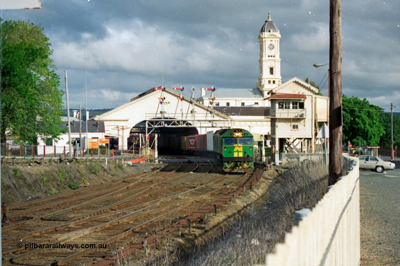 139-21
Ballarat station, Australian National broad gauge BL class BL 32 Clyde Engineering EMD model JT26C-2SS serial 83-1016 leading a down Adelaide bound goods train departs the station, crossing Lydiard Street in front of Ballarat B signal box, through the interlocked gates and under the semaphore signal gantry, with triple track to double track junction, point rodding, interlocking in the foreground.
Keywords: BL-class;BL32;Clyde-Engineering-Rosewater-SA;EMD;JT26C-2SS;83-1016;