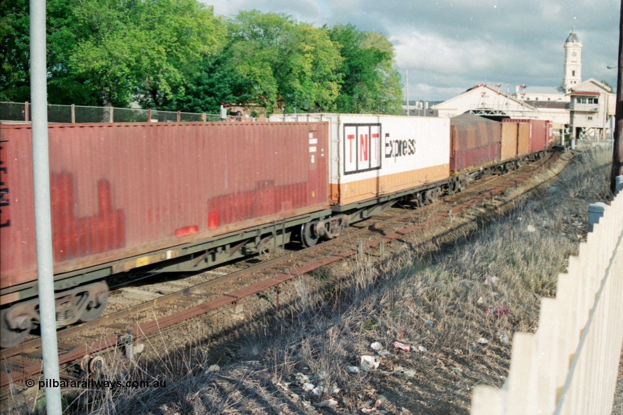 139-23
Ballarat, broad gauge Australian National AQKY type articulated 2-pack waggon with two 40 foot containers, part of a down Adelaide bound goods train, Ballarat station and Lydiard Street signal box in the background, point rodding and interlocking next to line.
Keywords: AQKY-type;