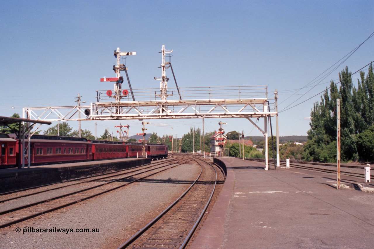 140-1-13
Ballarat station platform view from platform 1, E cars on No.5 Rd, looking east, A Box in the background, signal gantry semaphore signal post 23 is still in use, but as No.2 Rd has been removed signal post 22 has been stripped.
