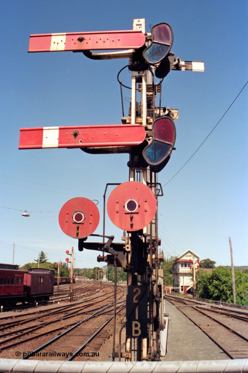 140-1-14
Ballarat station platform 1 view looking east, A signal box in the background, up departure semaphore signal post 21B the top arm is the up home to the up passenger line, bottom arm is the up home to No.1 A Rd, the left disc is to goods departure point 'X' or Siding Y and the right disc is to the goods track or loco track.
