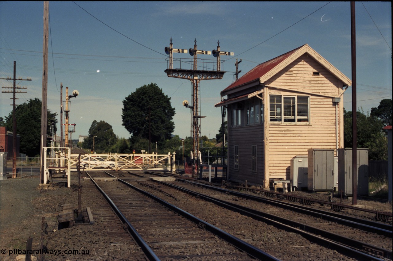 140-2-05
Ballarat, Linton Junction Signal Box, or Ballarat D, looking towards Ballarat, automatic staff exchange apparatus, staff exchange platform, disc signal 21, interlocked gates, triple doll semaphore signal post 20, left arm is Down Home to Cattle Yards Line, middle arm is Down Home to Linton Line, right arm is Down Home to Ararat Line, and the disc is for the Timken's Sidings.
