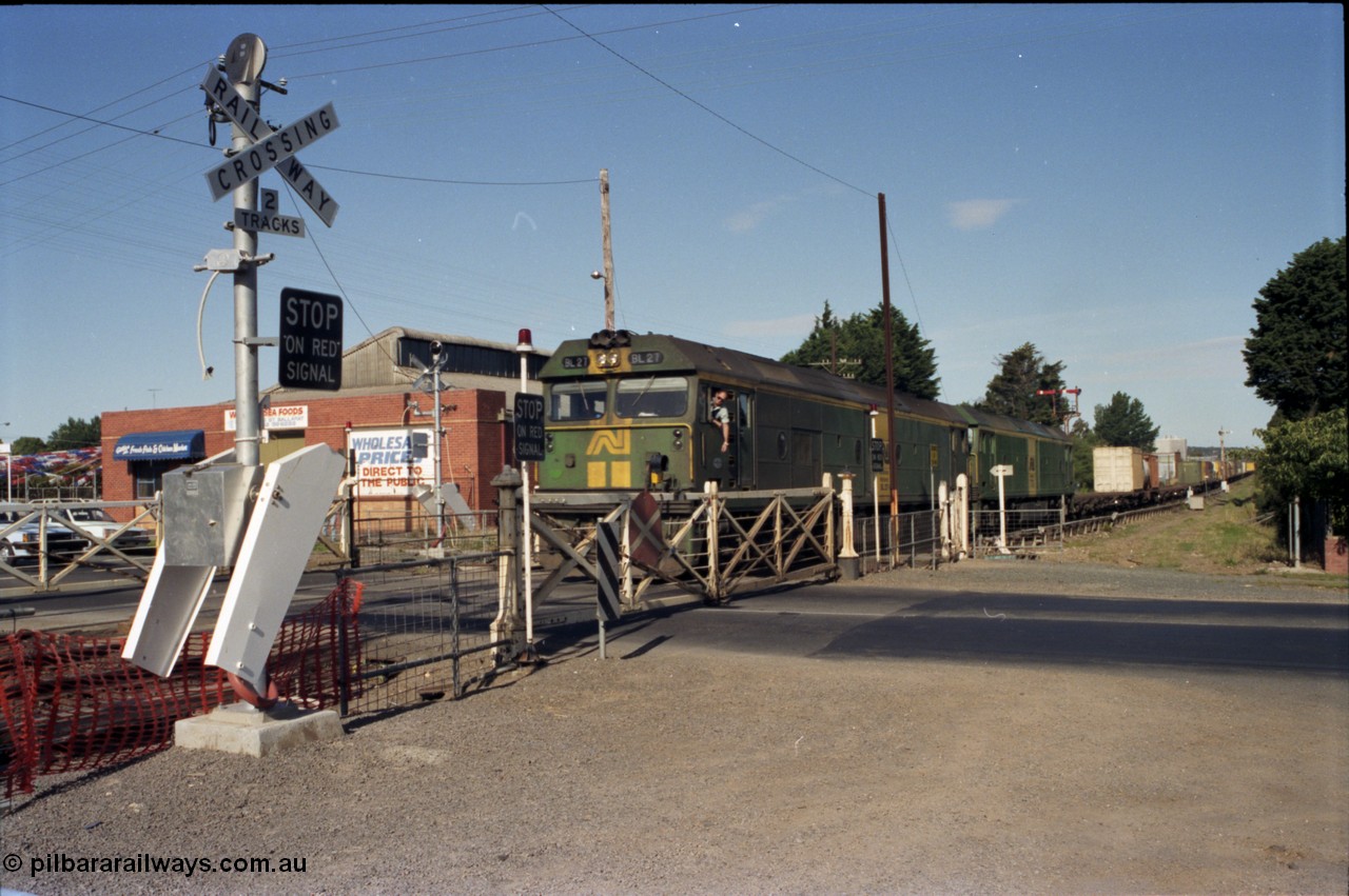 140-2-07
Ballarat, Linton Junction Signal Box, or Ballarat D, looking towards Ballarat, Australian National BL class BL 27 Clyde Engineering EMD model JT26C-2SS serial 83-1011 leads another BL class with an Adelaide bound down goods train at Linton Junction as the driver leans out the cab window to collect the electric staff for the section Linton Junction - Trawalla, crossing Gillies Street through the interlocked swing gates. The boom barrier installation will render these interlocked gate obsolete in a few weeks time.
Keywords: BL-class;BL27;Clyde-Engineering-Rosewater-SA;EMD;JT26C-2SS;83-1011;