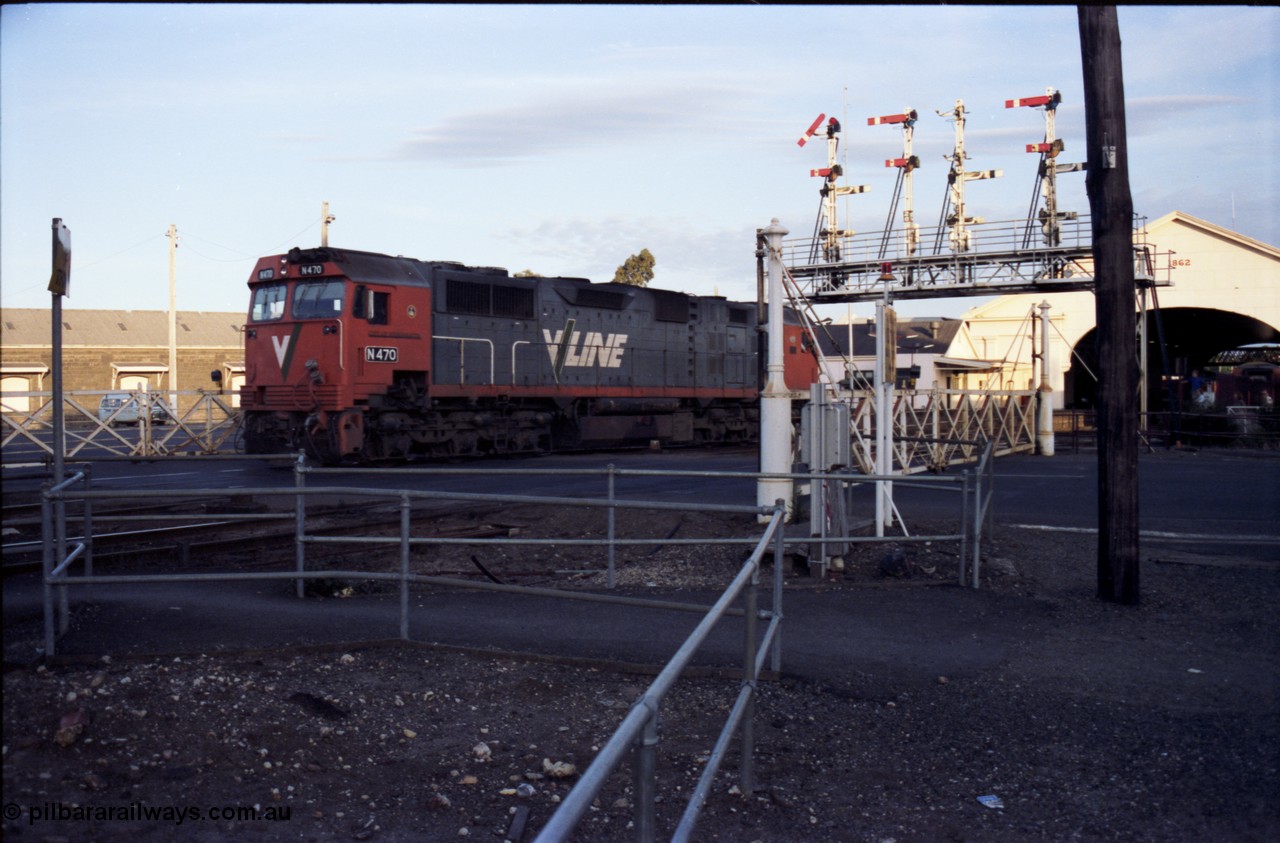140-2-14
Ballarat station, V/Line broad gauge N class N 470 'City of Wangaratta' Clyde Engineering EMD model JT22HC-2 serial 86-1199 crosses Lydiard Street as it runs round the carriage set, through the interlocked gates and under the signal gantry on No.4 Rd, semaphore signal post 29 is pulled off for the move, this signal is controlled from A Box, while the signal is across the road from B Box.
Keywords: N-class;N470;Clyde-Engineering-Somerton-Victoria;EMD;JT22HC-2;86-1199;