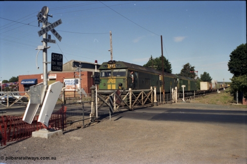 140-2-07
Ballarat, Linton Junction Signal Box, or Ballarat D, looking towards Ballarat, Australian National BL class BL 27 Clyde Engineering EMD model JT26C-2SS serial 83-1011 leads another BL class with an Adelaide bound down goods train at Linton Junction as the driver leans out the cab window to collect the electric staff for the section Linton Junction - Trawalla, crossing Gillies Street through the interlocked swing gates. The boom barrier installation will render these interlocked gate obsolete in a few weeks time.
Keywords: BL-class;BL27;Clyde-Engineering-Rosewater-SA;EMD;JT26C-2SS;83-1011;