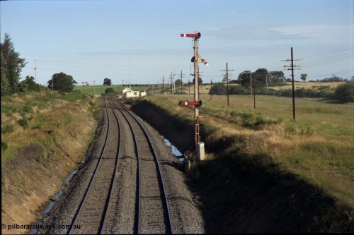 140-2-09
Warrenheip, station overview looking south, Melbourne line curves to the left and the Geelong line to the right, the Tamper track machine is in Siding A, the points and crossing lead to Siding B, signal box, staff exchange platform, notice how high the semaphore signal posts are.
