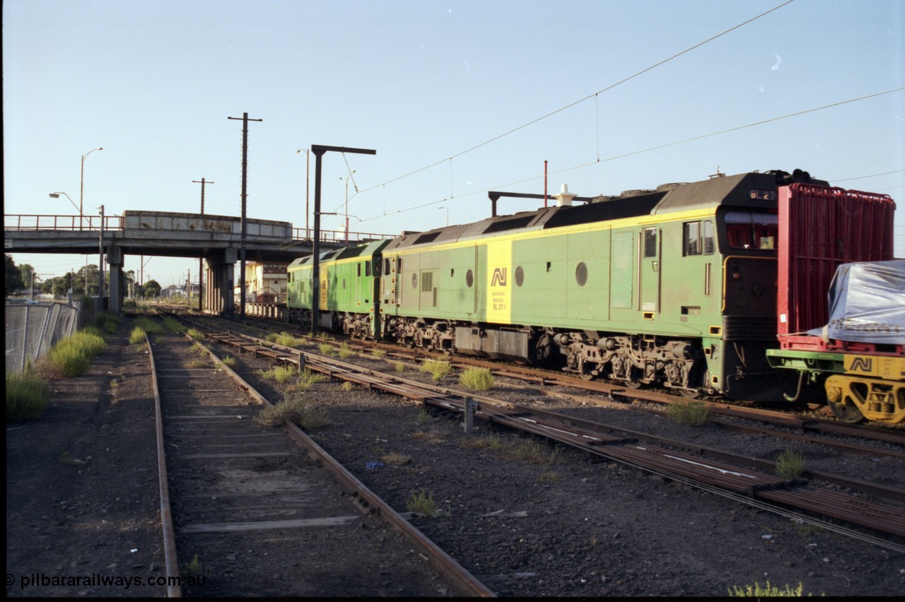 141-1-12
Sunshine, broad gauge Australian National BL class units BL 28 Clyde Engineering EMD model JT26C-2SS serial 83-1012 and BL 27 serial 83-1011 lead the second of the afternoon procession of down Adelaide bound goods trains out of Melbourne along platform No.3, point rodding, station platform, signal box, Hampshire Road overbridge, taken from former goods yard, trailing view.
Keywords: BL-class;BL27;Clyde-Engineering-Rosewater-SA;EMD;JT26C-2SS;83-1011;