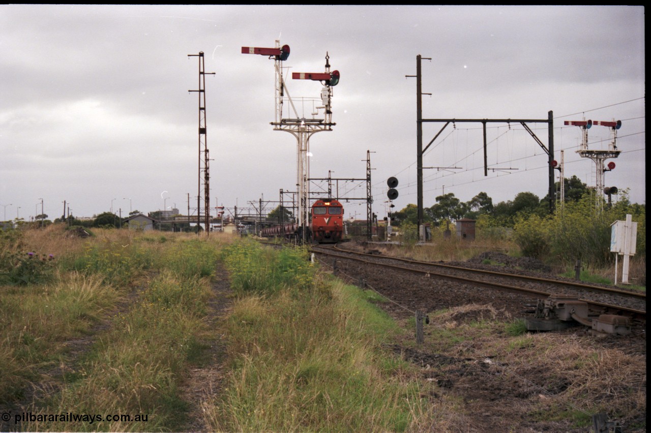 141-1-17
Sunshine, broad gauge V/Line G class loco G 538 Clyde Engineering EMD model JT26C-2SS serial 89-1271 leads the up afternoon Apex Quarry train to Brooklyn as it swings across the passenger lines and onto the Newport Loop Line, the semaphore signal post 36 protects down trains off this line. The dual control point machine is for the points into the GEB sidings, the up home signal is cut off in this view.
Keywords: G-class;G538;Clyde-Engineering-Somerton-Victoria;EMD;JT26C-2SS;89-1271;