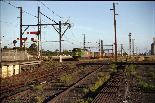 141-1-04
Sunshine, broad gauge down Adelaide goods train behind Australian National BL class and a V/Line G class cross over the passenger lines from the Independent Through Lines heading for No.3 road and the main western line, station platform, semaphore and disc signal posts, points, point rodding, looking east, Newport Loop Line on the right.
Keywords: BL-class;BL33;Clyde-Engineering-Rosewater-SA;EMD;JT26C-2SS;83-1017;