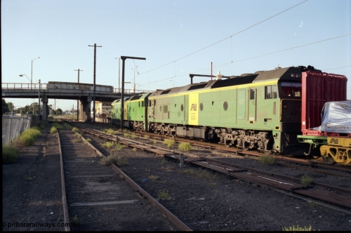 141-1-12
Sunshine, broad gauge Australian National BL class units BL 28 Clyde Engineering EMD model JT26C-2SS serial 83-1012 and BL 27 serial 83-1011 lead the second of the afternoon procession of down Adelaide bound goods trains out of Melbourne along platform No.3, point rodding, station platform, signal box, Hampshire Road overbridge, taken from former goods yard, trailing view.
Keywords: BL-class;BL27;Clyde-Engineering-Rosewater-SA;EMD;JT26C-2SS;83-1011;