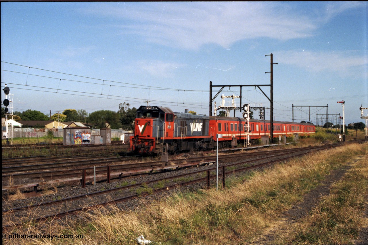 141-2-01
Sunshine, broad gauge V/Line P class P 14 Clyde Engineering EMD model G18HBR serial 84-1208 rebuilt from T 330 Clyde Engineering EMD model G8B serial 56-85 with a six car H set push-pull down passenger train with fellow P class P 21 serial 84-1214 rebuilt from T 338 serial 56-114 on the rear, searchlight signal post to left is the Up Home for the standard gauge Sunshine Loop, the Newport - Sunshine Loop Line can be seen in the foreground, the semaphore signal at right if for the Newport Loop Line, disc for the GEB Sidings, the double doll semaphore signal post and disc post above the lead carriage is for the Independent Through Goods Lines.
Keywords: P-class;P14;Clyde-Engineering-Somerton-Victoria;EMD;G18HBR;84-1208;rebuild;