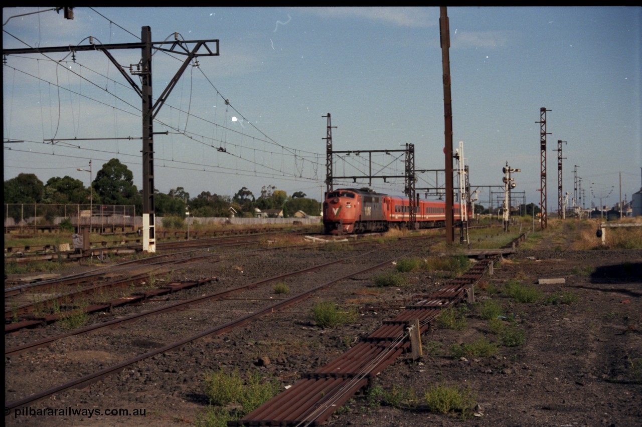 141-2-07
Sunshine, broad gauge V/Line A class A 78 Clyde Engineering EMD model AAT22C-2R serial 84-1185 rebuilt from B 78 Clyde Engineering EMD model ML2 serial ML2-19 with an N set and D van on a down Ballarat passenger train head onto No.3 Rd, point rodding.
Keywords: A-class;A78;Clyde-Engineering-Rosewater-SA;EMD;AAT22C-2R;84-1185;rebuild;bulldog;