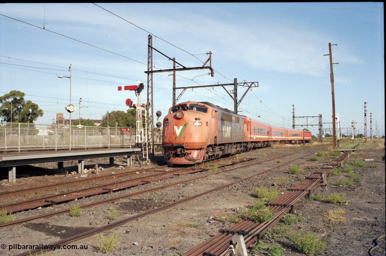 141-2-08
Sunshine, broad gauge V/Line A class A 78 Clyde Engineering EMD model AAT22C-2R serial 84-1185 rebuilt from B 78 Clyde Engineering EMD model ML2 serial ML2-19 with an N set and D van on a down Ballarat passenger train head into Sunshine platform No.3 past semaphore and disc signal post 33, point rodding, station platform.
Keywords: A-class;A78;Clyde-Engineering-Rosewater-SA;EMD;AAT22C-2R;84-1185;rebuild;bulldog;