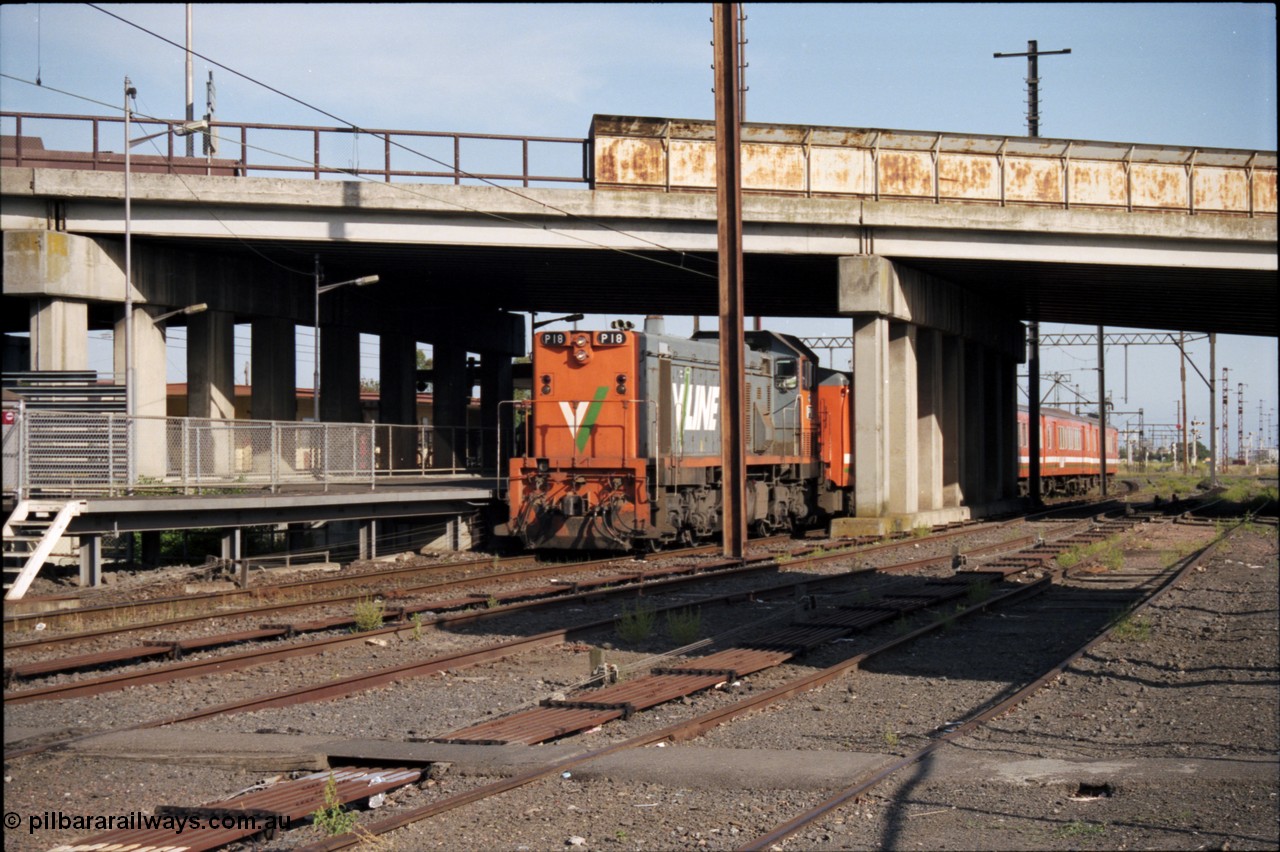 141-2-10
Sunshine, broad gauge V/Line P class P 18 Clyde Engineering EMD model G18HBR serial 84-1211 rebuilt from T 339 Clyde Engineering EMD model G8B serial 56-115 leads an H set underneath the Hampshire Road overbridge with a down Bacchus Marsh passenger train at platform No.3, taken from the remains of Sunshine goods yard, point rodding.
Keywords: P-class;P18;Clyde-Engineering-Somerton-Victoria;EMD;G18HBR;84-1211;rebuild;