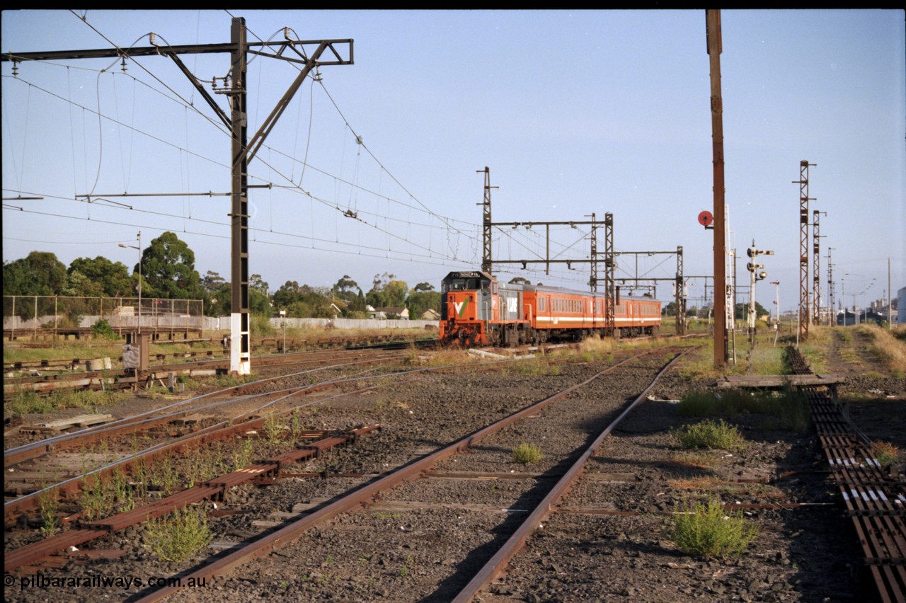 141-2-22
Sunshine, V/Line broad gauge P class P 15 Clyde Engineering EMD model G18HBR serial 84-1209 rebuilt from T 344 Clyde Engineering EMD model G8B serial 56-127 with a three car H set arrives on a down Bacchus Marsh passenger service, the point rodding is clearly visible for the interlocked points of the area.
Keywords: P-class;P15;Clyde-Engineering-Somerton-Victoria;EMD;G18HBR;84-1209;rebuild;