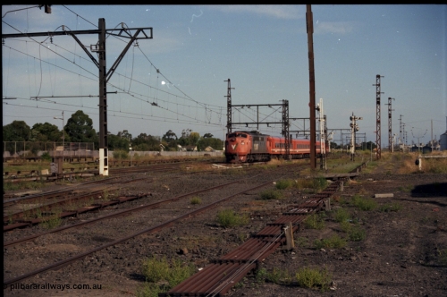 141-2-07
Sunshine, broad gauge V/Line A class A 78 Clyde Engineering EMD model AAT22C-2R serial 84-1185 rebuilt from B 78 Clyde Engineering EMD model ML2 serial ML2-19 with an N set and D van on a down Ballarat passenger train head onto No.3 Rd, point rodding.
Keywords: A-class;A78;Clyde-Engineering-Rosewater-SA;EMD;AAT22C-2R;84-1185;rebuild;bulldog;