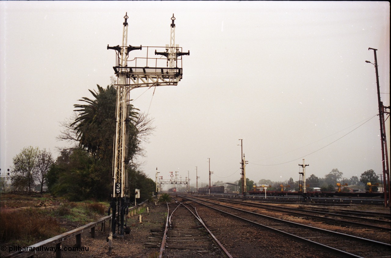 142-1-21
Benalla station yard view from Siding Z and oil siding points, signal post 35 stripped, points and crossover from Siding Z to mainline removed, stripped signal disc posts 32 and 29 on the right.
