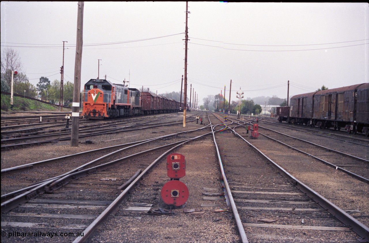 142-1-23
Benalla station yard overview looking south, dwarf disc signals 18 and 17 facing camera, 9303 stabled Wodonga goods with V/Line broad gauge locos X class X 48 Clyde Engineering EMD model G26C serial 75-795 and T class T 408 Clyde Engineering EMD model G18B serial 68-624, taken from Siding K, Dock D beside train, then 4, 5 and 6 Roads, dwarf discs facing away are 15, 13 and 10, disc signal post 12, NSW louvre vans at right.
Keywords: X-class;X48;Clyde-Engineering-Rosewater-SA;EMD;G26C;75-795;