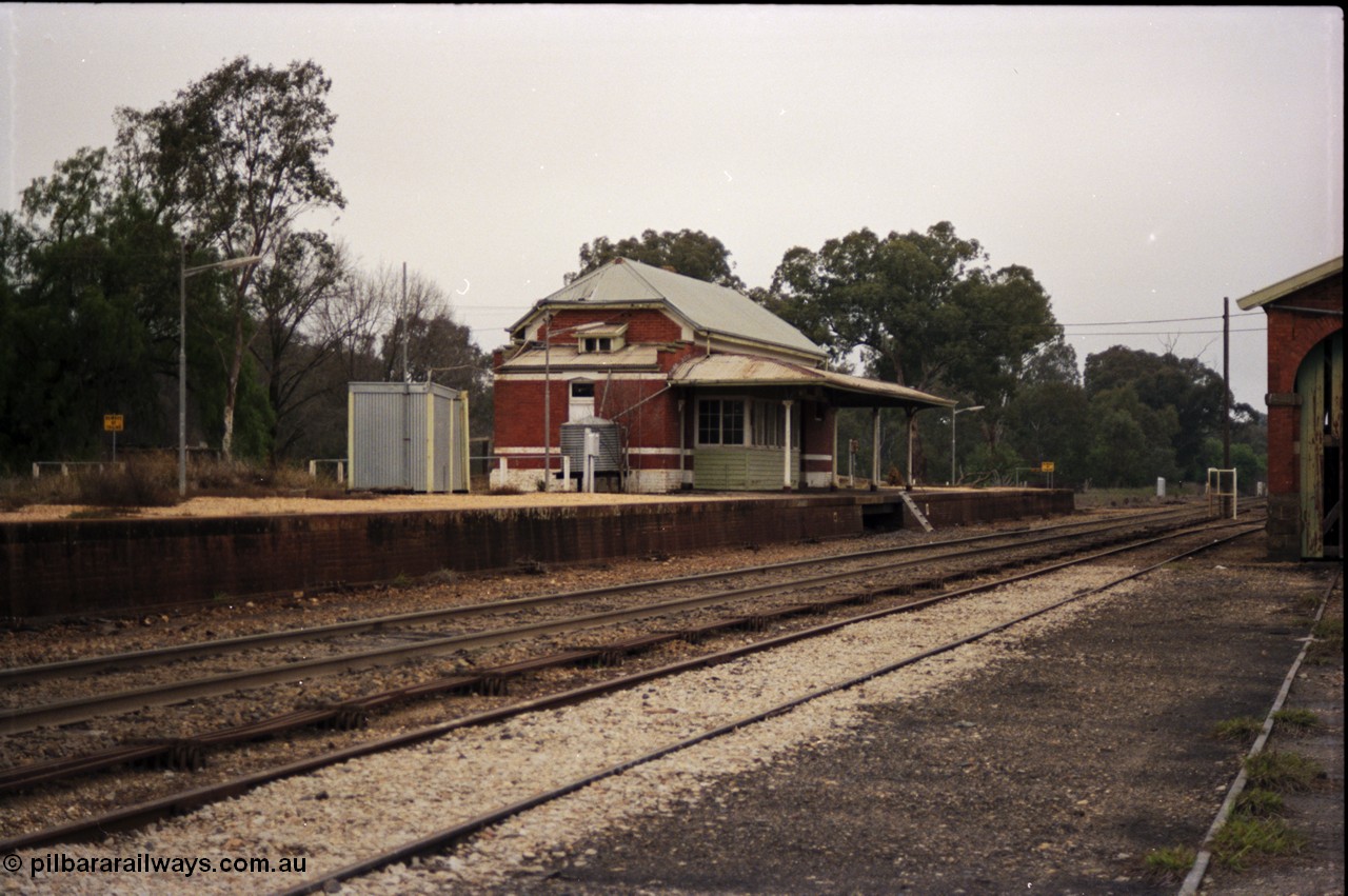 142-2-09
Barnawartha station building and yard overview looking south, point rodding down middle of yard, goods shed at extreme right, standard gauge runs behind station building.
