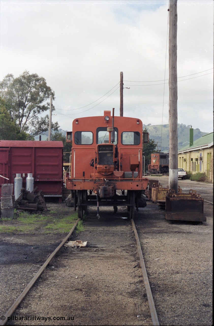 142-2-20
Wodonga loco depot, V/Line broad gauge shunting rail tractor RT class RT 47, long hood view, grounded B van, turntable behind tractor. RT 47 was built by Victorian Railways as an I type waggon I 7214 in September 1904, converted to IA in 1934, then Ballarat Workshops converted it into the underframe during July 1969 for RT 47.
Keywords: RT-class;RT47;Victorian-Railways-Ballarat-Nth-WS;I-type;IA-type;I7214;IA7214;