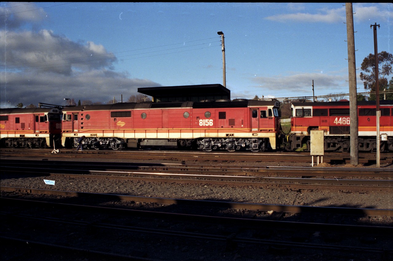 142-3-08
Albury station yard, standard gauge NSWSRA candy liveried 81 class 8156 Clyde Engineering EMD model JT26C-2SS serial 84-1075 sandwiched between sister 81 class 8180 serial 85-1099 and 44 class 4466 AE Goodwin ALCo model DL500B serial G3421-06, the hostler is winding off the handbrakes on 8156.
Keywords: 81-class;8156;Clyde-Engineering-Kelso-NSW;EMD;JT26C-2SS;84-1075;