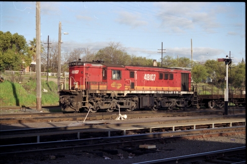 142-3-07
Albury loco depot, yard shunter, standard gauge NSWSRA candy liveried 48 class 48107 AE Goodwin ALCo model DL531 serial G3420-22 with shunters float rests between shunt jobs on Sunday afternoon, semaphore signal, point lever, point rodding under metal walkway.
Keywords: 48-class;48107;AE-Goodwin;ALCo;DL531;G3420-22;