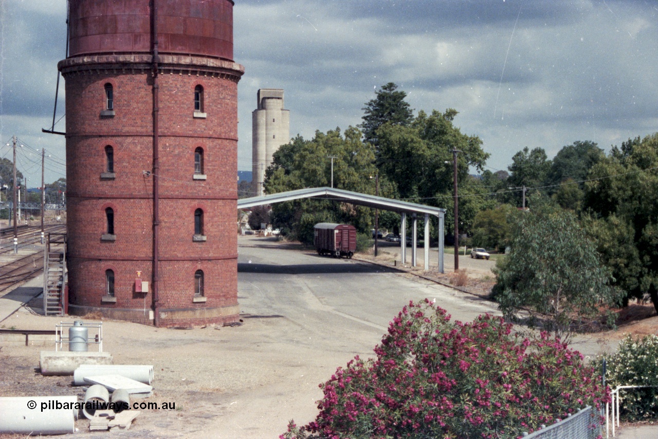 143-02
Wangaratta, goods area, water tower and Freight Gate canopy with V/Line bogie louvre van and silos in the distance, taken from footbridge.
