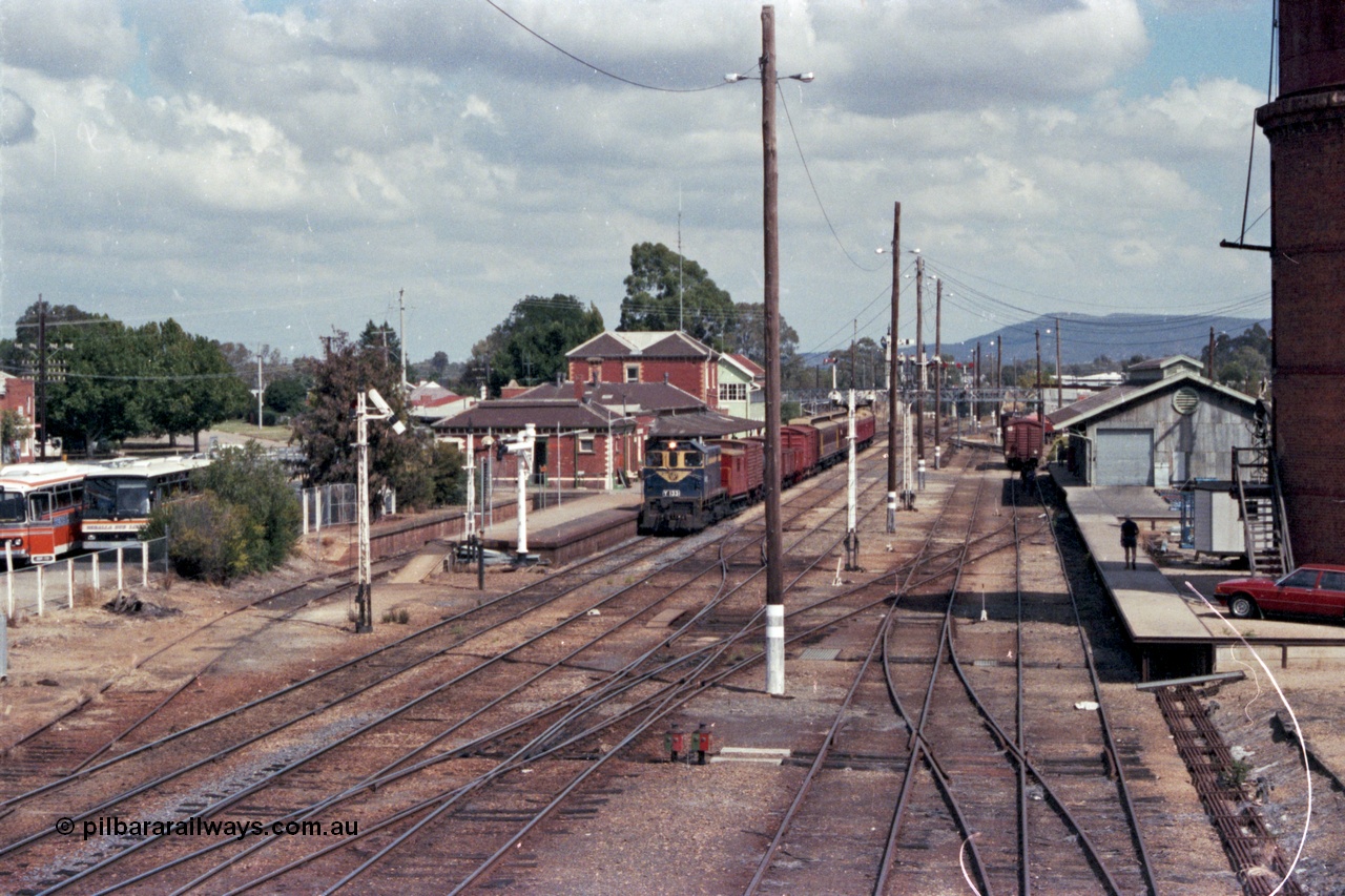 143-04
Wangaratta station yard overview looking south from footbridge, VR liveried Y class Y 133 Clyde Engineering EMD model G6B serial 65-399 brings the board gauge down Wahgunyah Special 'Stringybark Express' to a stop at the platform, the fully interlocked yard and 18th century infrastructure clearly on display here, semaphore signal Post 20 is pulled off for departure, station building and platform, elevated signal box, signal posts and interlocking, goods shed and water tower.
Keywords: Y-class;Y133;Clyde-Engineering-Granville-NSW;EMD;G6B;65-399;